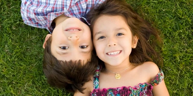 boy and girl on top of grass