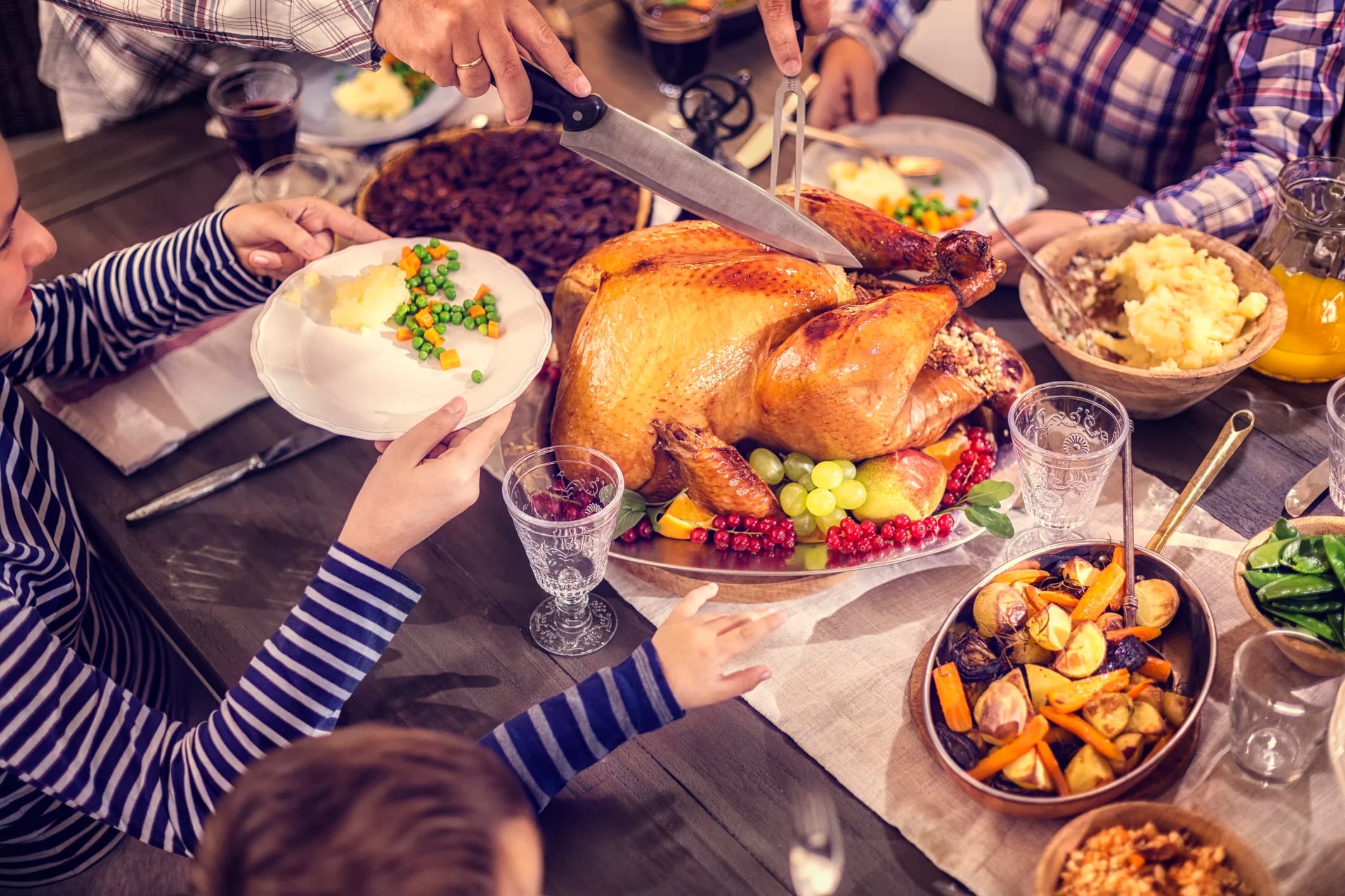 family at a table with a turkey in the center