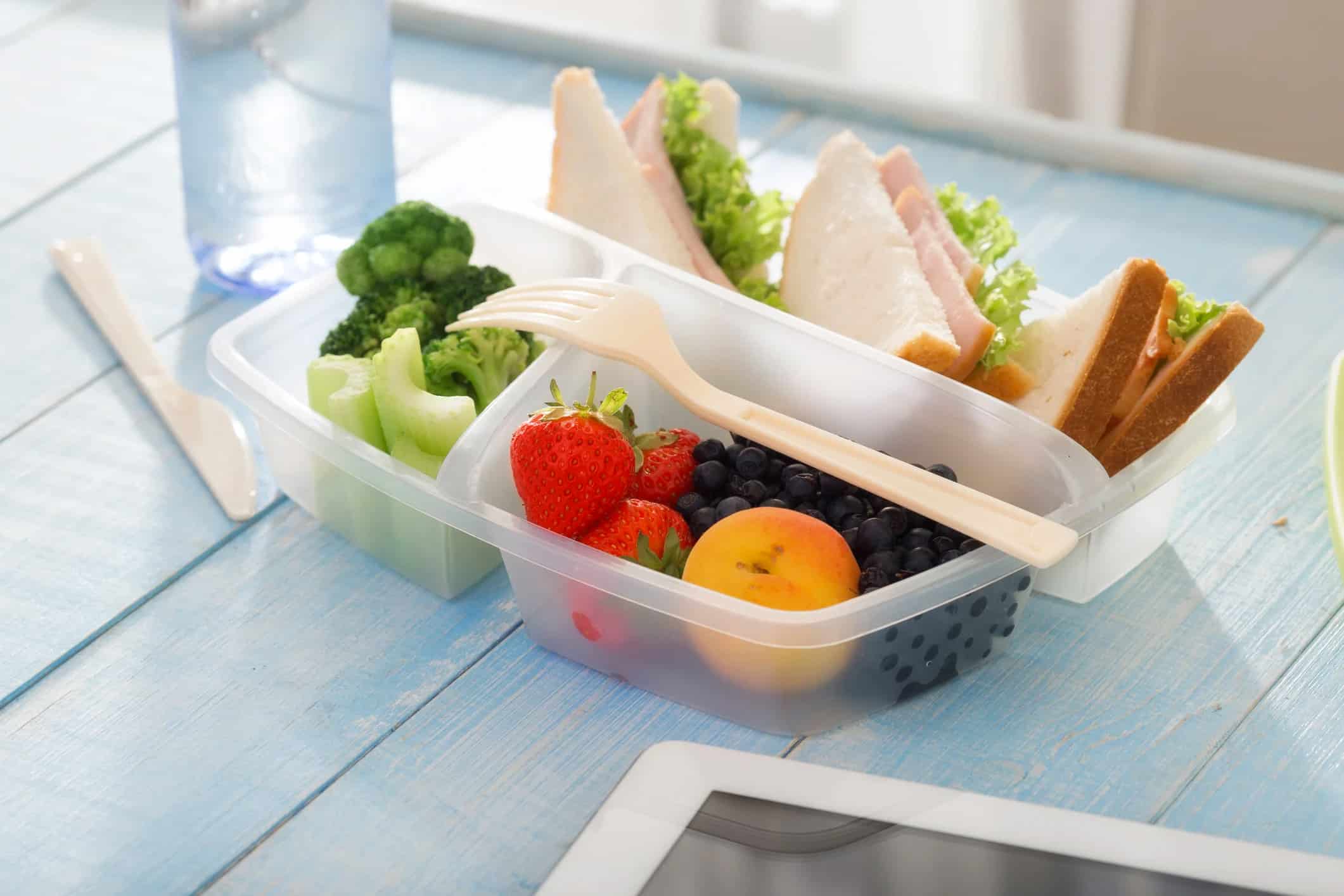 boxed lunch with triangle sandwich bites and fruit