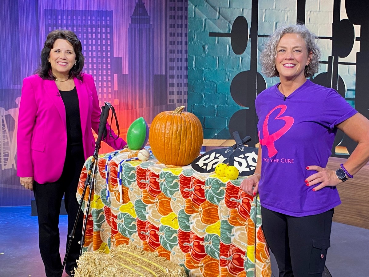 Mo Smith of Bailey Bariatrics stands with a News On 6 host beside pumpkin, hay bale and other fall fitness props.