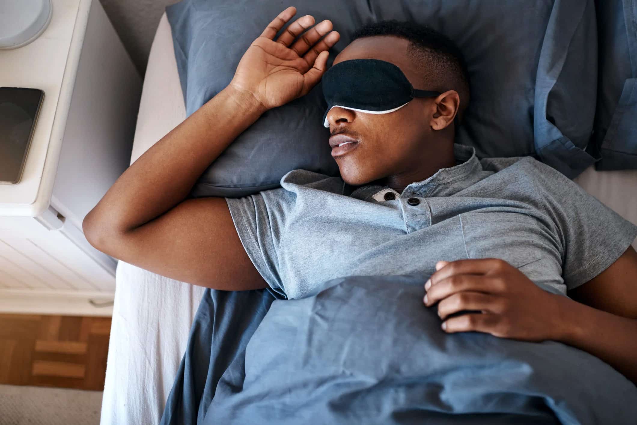 man with sleep mask on lying in bed