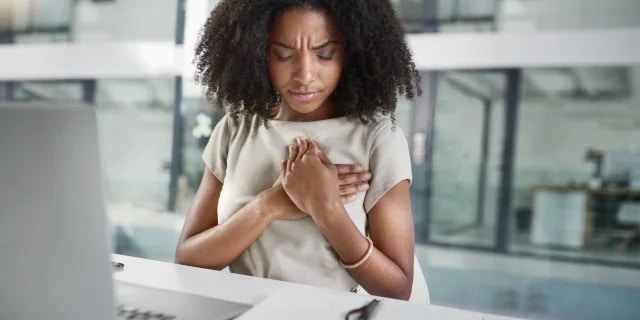 woman holding her chest in pain