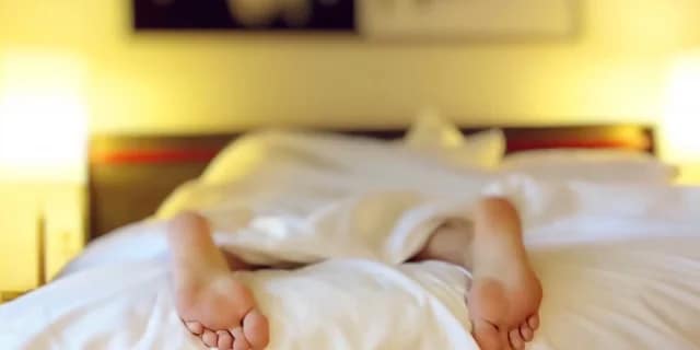 person sleeping in be with their feet sticking out the bottom