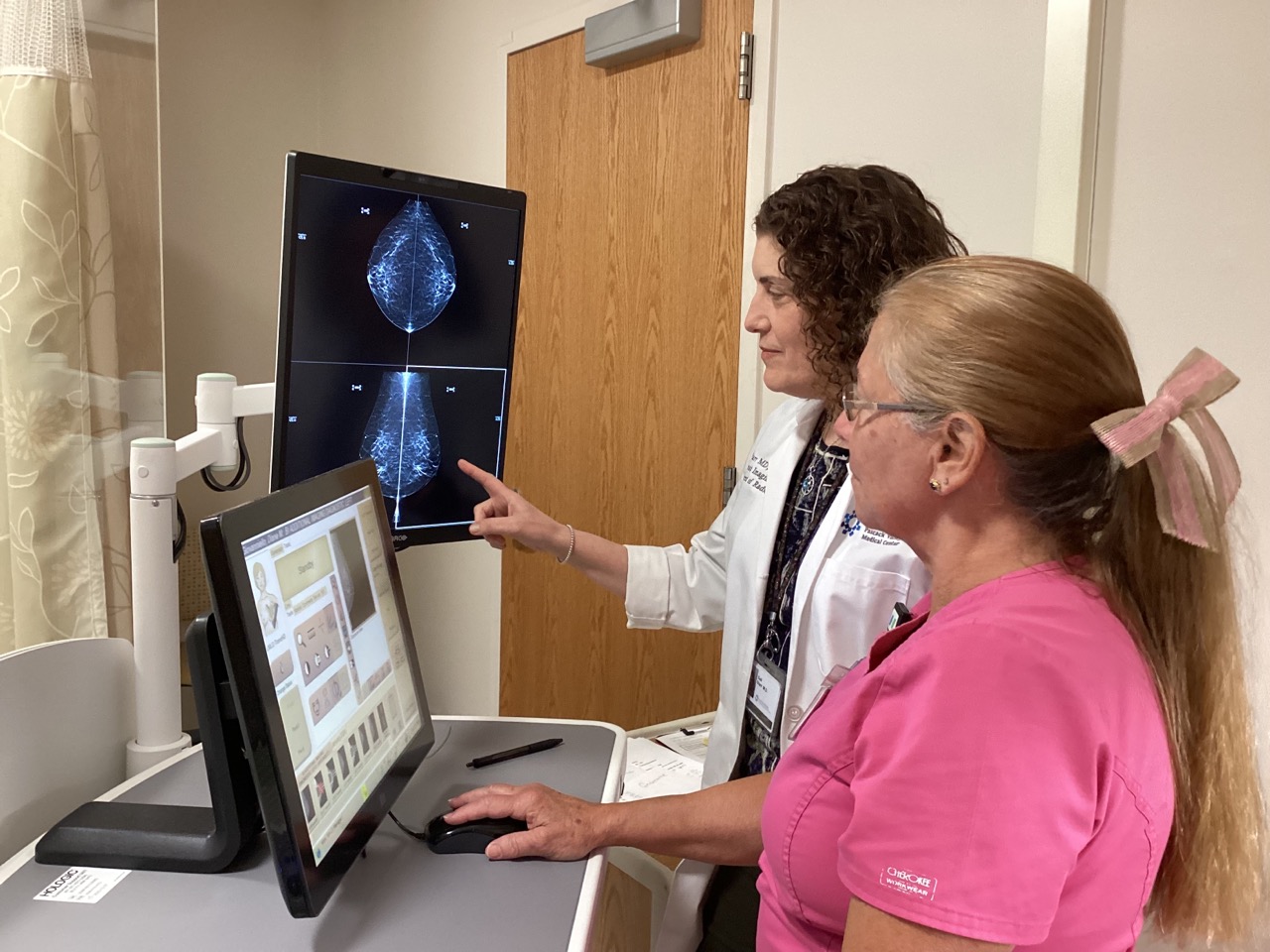 Two doctors looking at screen using Mammography™ with SmartCurve™ software