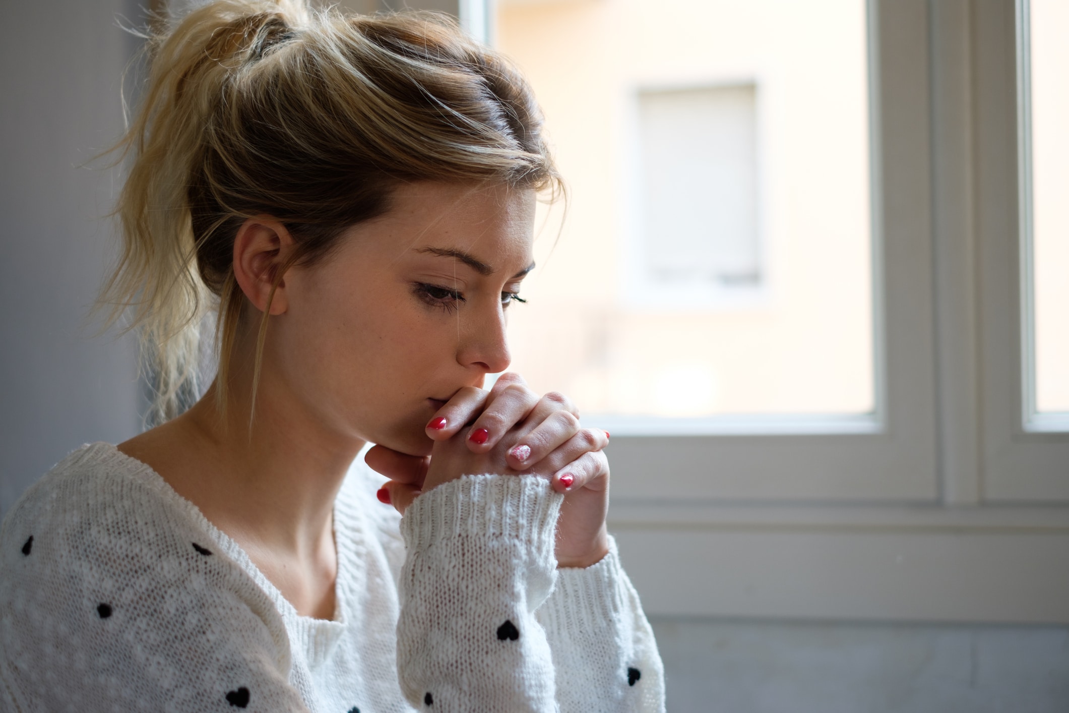 Worried and alone girl next to the window light