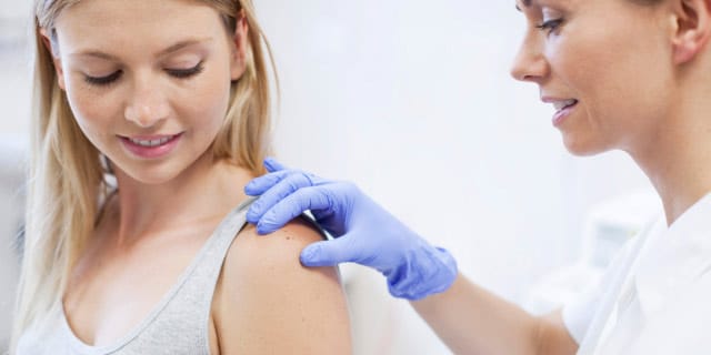 woman doctor examing a woman's arm
