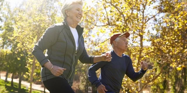 elderly couple running outside